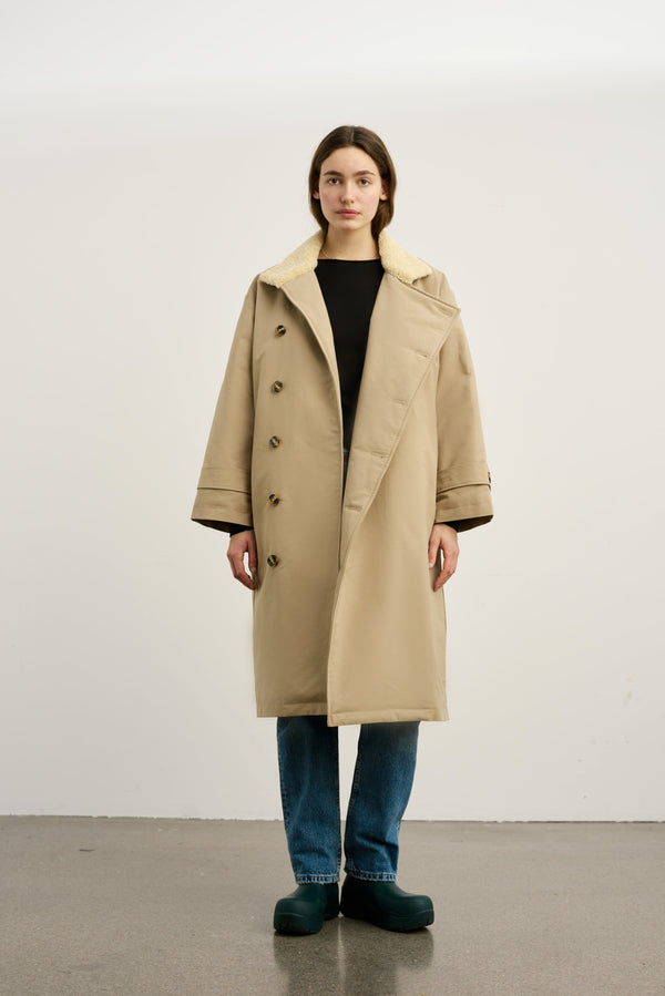 Dame i en stilren beige frakk fra MEOTINE, perfekt for høst- og vintermote. Kvalitet og komfort i fokus.