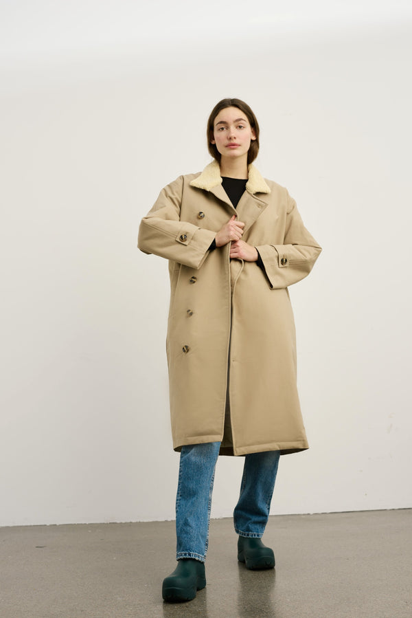 Dame i en stilren beige frakk fra MEOTINE, perfekt for høst og vinter. Kvalitet og komfort i ett.