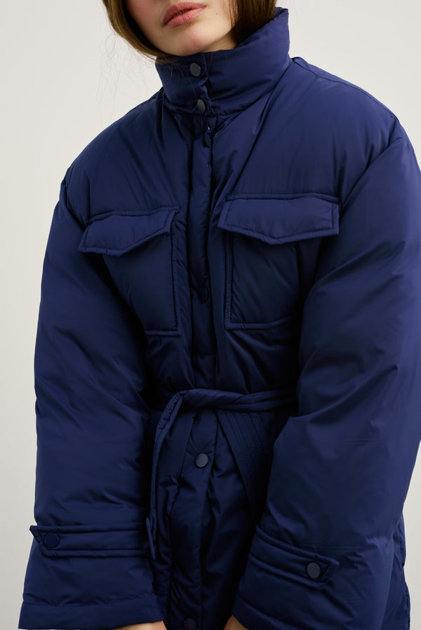 Dame iført en stilren, blå jakke fra MEOTINE, perfekt for kalde dager med komfort og stil.