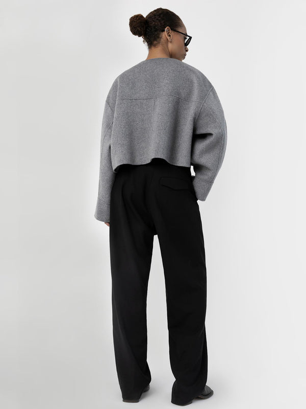 Modellen viser en grå MEOTINE-jakke med brede bukser, perfekt for en moderne stil.