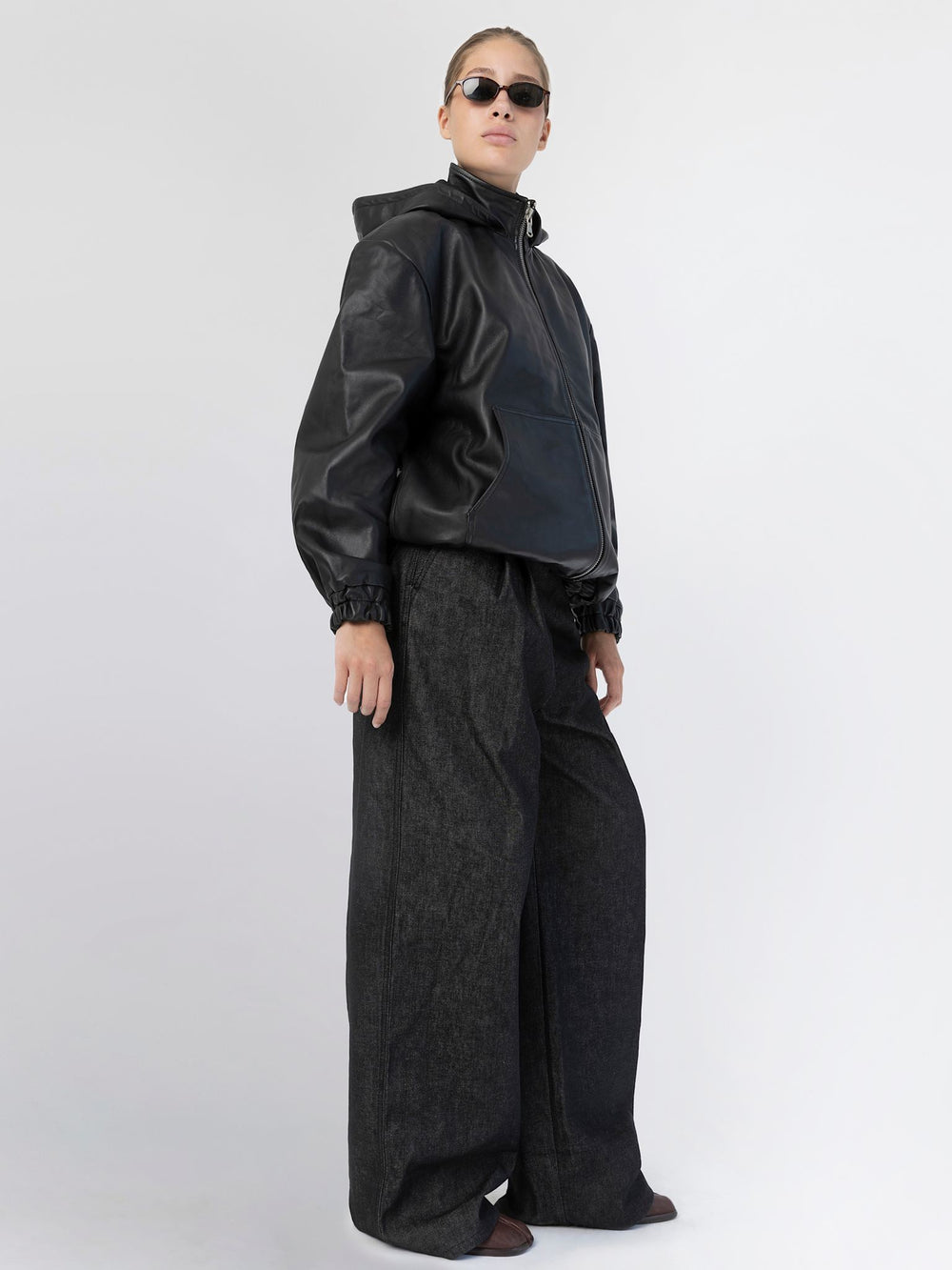 Modell iført svart skinnjakke fra MEOTINE, med solbriller og stilige bukser.