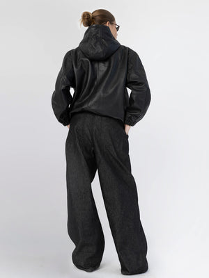 Modellen har på seg en svart jakke og vide bukser fra MEOTINE, perfekt for en trendy look.