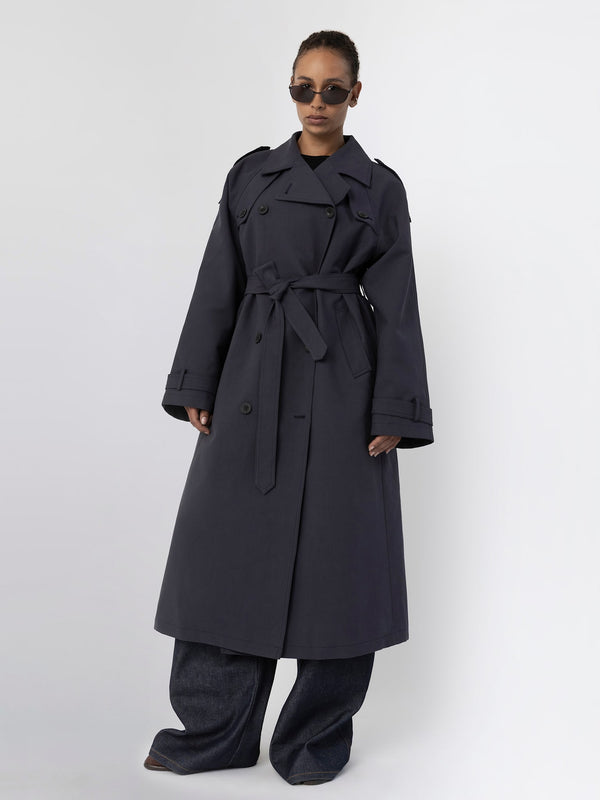 MEOTINE trenchcoat i mørkeblå, med belte og brede bukser, perfekt for stilige anledninger.