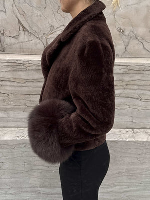 Dame i en luksuriøs brun skinnjakke fra MEOTINE, med myke pelsdetaljer for en elegant stil.