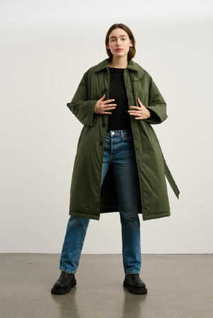 Dame i en stilren, grønn jakke fra MEOTINE, perfekt for høst- og vintermote. Kombineres enkelt med jeans.