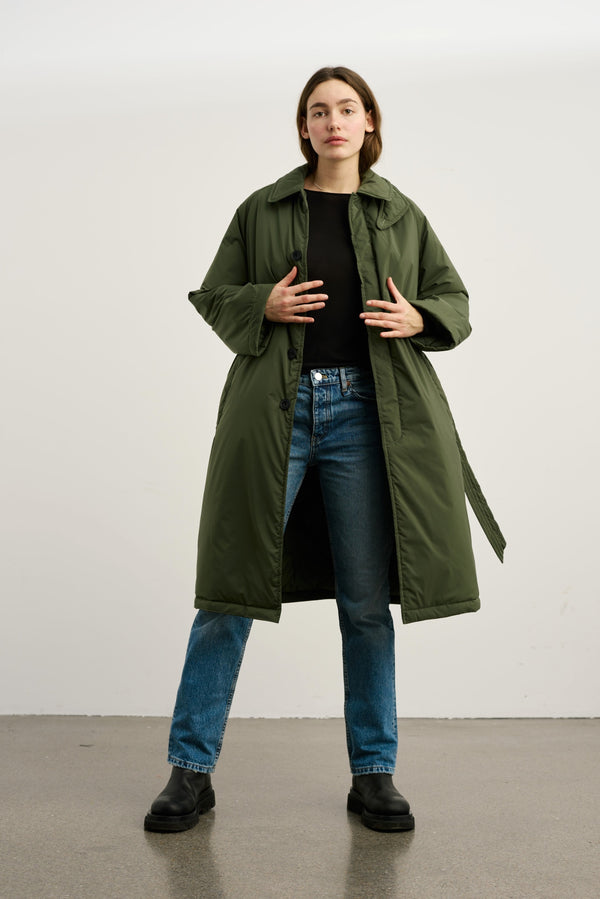 Dame i en stilren, grønn jakke fra MEOTINE, perfekt for høst- og vintermote. Kombineres enkelt med jeans.