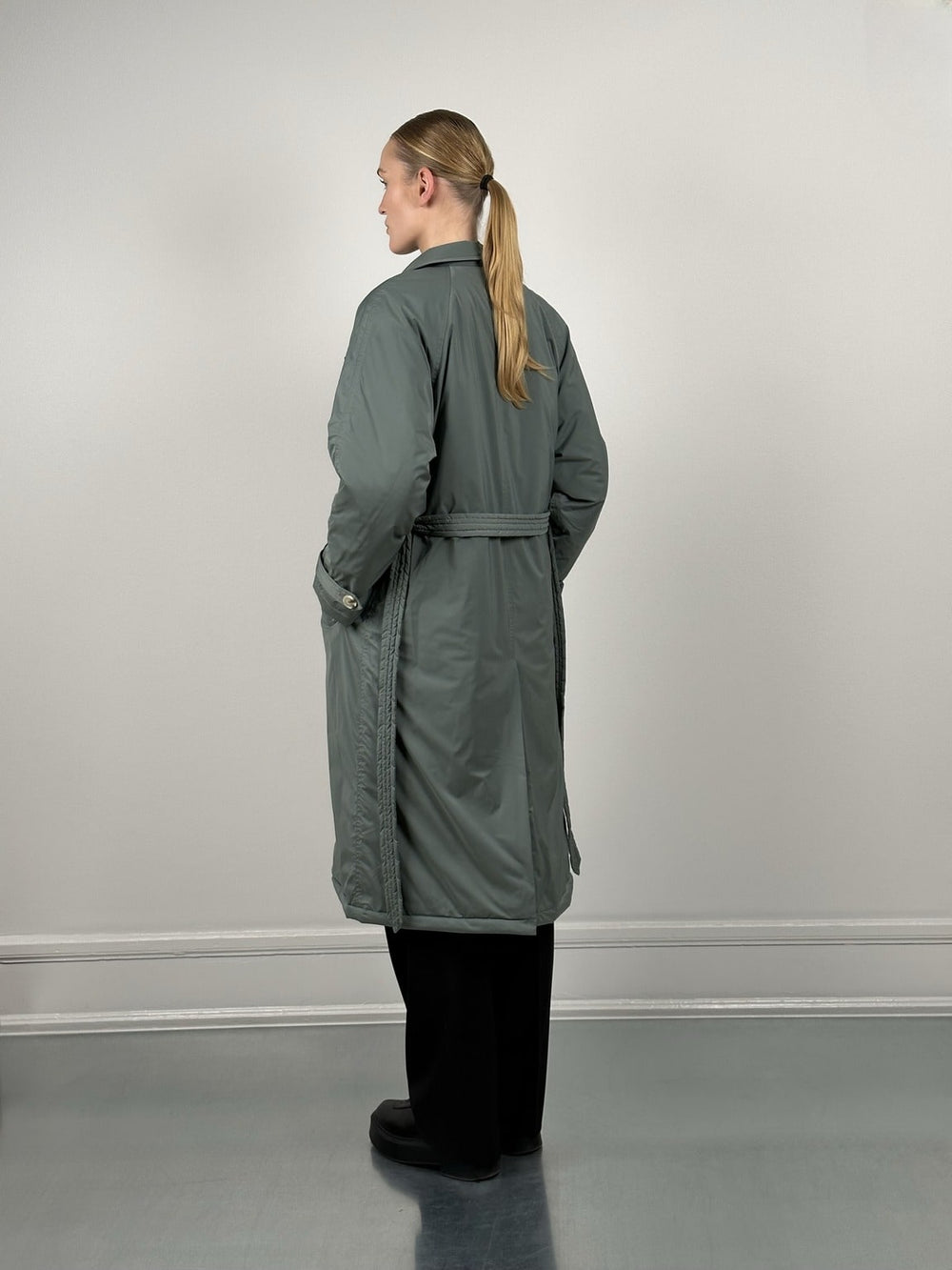 Dame i en stilren, grønn trenchcoat fra MEOTINE, perfekt for enhver anledning. Kvalitet og design i fokus.
