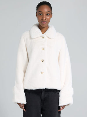 Dame i en stilren, hvit jakke fra MEOTINE. Perfekt for en moderne garderobe med komfort og eleganse.