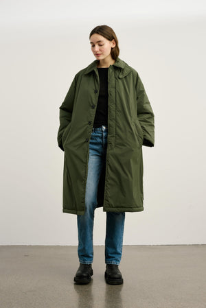 Dame i en stilren, grønn jakke fra MEOTINE, perfekt for høst- og vintermote. Komfort og stil i ett.