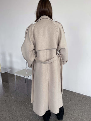 Dame i en stilren beige kåpe fra MEOTINE, perfekt for enhver anledning med elegant snitt og detaljer.