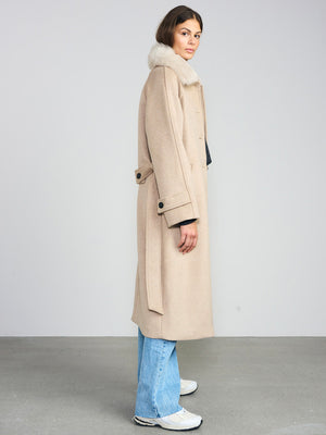 Dame i en stilren beige frakk med pelskrage fra MEOTINE, perfekt for høst- og vintermote.