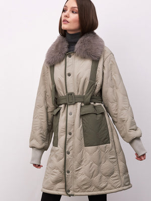 Dame i en stilren jakke fra MEOTINE, med pelskrage og belte for en moderne look. Perfekt for kalde dager.